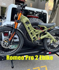 Heavy Duty Full Suspension Electric Bike With Four Thousand Watts Dual Motors And Massive Fifty Two Volt Battery parked on a bike rack.