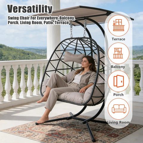 Woman relaxing on double hanging egg chair with canopy and stand for two people, outdoor rattan hammock swing chair with 700 lbs capacity.