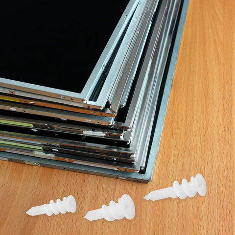 Plastic anchors on a wooden surface with stacked metal frames; part of 300-Piece Heavy Duty Plastic Drywall Anchors Kit With Spiral Expansion Tubes