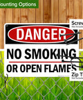 Straight Up Danger No Smoking Or Open Flames Sign 10X14 Inches.040 Rust Free Aluminum Fire Safety Warning Plaque mounted on a fence.