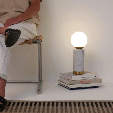 Aspen LED Table Lamp With USB Port For Bedside Or Desk Ambient Lighting And Marble Finish Globe Shade on books beside chair