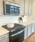 Modern kitchen with cabinets featuring door and drawer pulls 6-inch center-to-center brushed titanium gold finish, pot on stove.