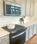 Modern kitchen with white cabinetry and stove, featuring Lexington 6 Inch Center To Center Door And Drawer Pulls Matte Black 10 Pack.