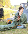 Person sitting in Cold Weather Mummy Sleeping Bag For Hiking And Camping With No Snag Zipper 20 Degree Temperature Rating