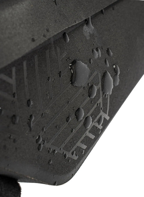 Close-up of the waterproof surface of the Midloader Drybag For Bike Frame Waterproof Medium Size With Hidden Weatherproof Zipper And Flap Reflective Logo Dual Side Zippers And Slim Pocket For Small Gear TPU Construction For Commuters And Trail Riders Go To Everyday Rides showcasing water droplets on black material with reflective logo.