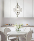 Chrome 12-Inch One-Light Crystal Pendant Light With Moroccan Quatrefoil Glam Design, over elegant dining table.