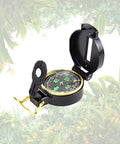 Outdoor Adventure Kit For Kids With Real Walkie Talkies, Binoculars, Flashlight, Compass, Magnifier, Whistle, Camouflage Hat And Backpack For Backyard Missions, Park Explorations, And Indoor Quests focusing on a compass next to jungle leaves.