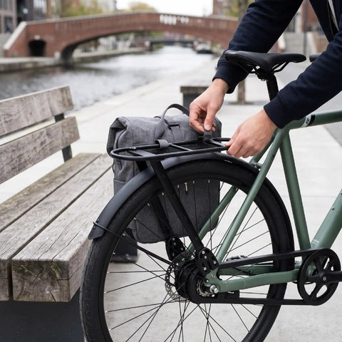 Sleek Carbon Fiber And Aluminum Rear Bike Rack For Mountain And Road Bikes Built Different To Haul Gear Reliably Every Time Without Extra Bulk Or Concerns, shown attaching to bike with commuter bag.