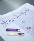 ECG Calipers Measuring Tool For Nurses And Docs, EKG Calipers And Caliper Divider For Electrocardiograms in purple on medical sheet