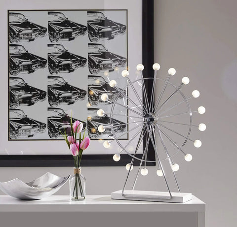 Coney Large LED Ferris Wheel Desk Lamp With Chrome Finish on modern office table with floral and car art background