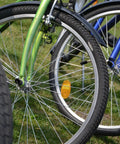 Close-up of bicycle front wheels with grass background