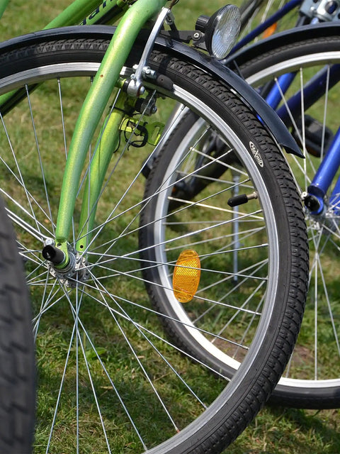 Close-up of bicycle front wheels with grass background