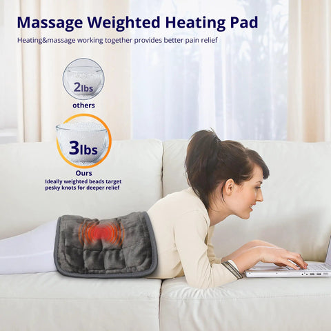 Woman lying on sofa using a laptop with a weighted heating pad with vibrating massage on her back, 12x24 inch, black.