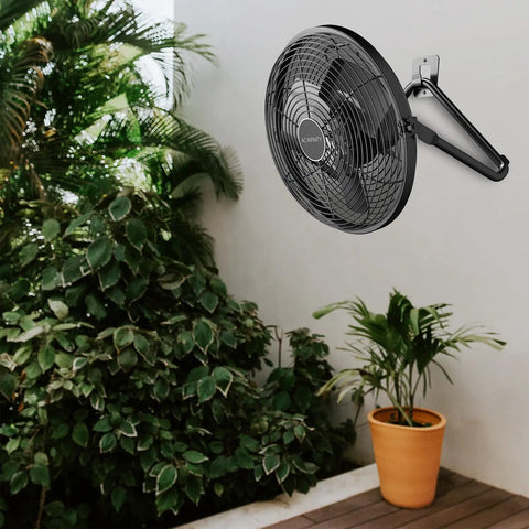12-Inch Industrial Wall and Floor Fan With Wireless 10-Speed Controller, EC Motor, mounted on wall near plants