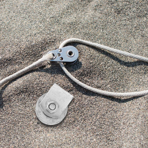 Heavy Duty Pulley Wheel Track Roller For Sliding Gates And Garage Doors Beefy Stainless Steel Design shown with rope on sand