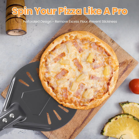 Front view of Leightszen pizza turning peel, perforated aluminum, dark gray, with pineapple pizza on wooden board.
