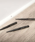 Pro Grade 3 Piece 5 Inch Steel Punch Set With Black Oxide Finish, Laser Etched Size Markings 1/32 2/32 3/32 Inch on a wooden surface