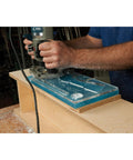 Top Shelf Cleaver Style Cutting Board Router Template used with a router on a workbench, clear acrylic jig with dual slots.