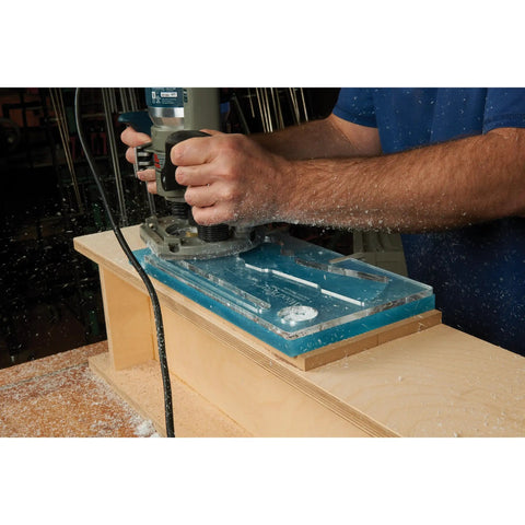 Top Shelf Cleaver Style Cutting Board Router Template used with a router on a workbench, clear acrylic jig with dual slots.