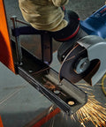 Heavy Duty 4 Inch Angle Grinder With Slick Paddle Switch And Lockdown Ergonomic Handle cutting metal with sparks flying.