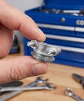 Hand holding a zinc alloy cable clamp, showcasing threaded connectors for electrical conduit wiring. Heavy Duty Four Pack Three Quarter Inch Cable Clamps Zinc Alloy Threaded Connectors For Electrical Conduit Wiring With Knockout Vibration Resistance And No Fuss Mounting Built Badass Tough.