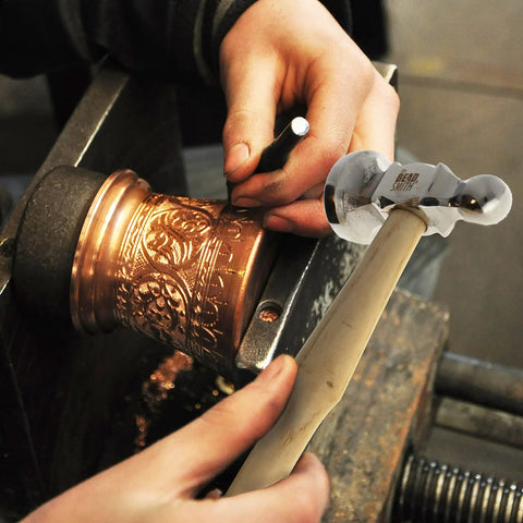 Metalworker using Two-Sided Chasing Hammer With Wooden Handle And Steel Head, 14mm Ball Pein for embossing metal artwork.