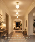 Mid Century Modern Globe Ceiling Light With Frosted Glass Ball And Totally Slick Gold Brass Finish Knockout Semi Flush Mount Fixture Comes With Dimmable E26 Warm Bulb For Hallway Stairs Or Closets in a stylish hallway.