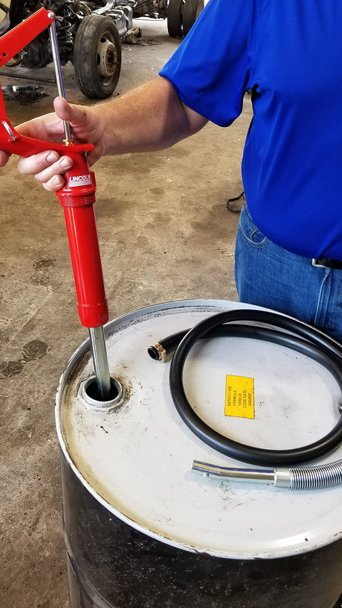 Person using Lincoln 1335 Lever Action Fluid Transfer Pump For 16 To 55 Gallon Drums With 8.5 Fluid Ounces Per Stroke, 2 Inch Bung