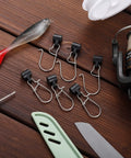 Set of opened duo lock clips from 50 Piece Sinker Slide Kit With Duo Lock Clips And Hooked Sinker Line Connectors For Freshwater And Saltwater Fishing Stainless Steel Snaps Durable Tackle Pro Grade on wooden background with fishing gear.