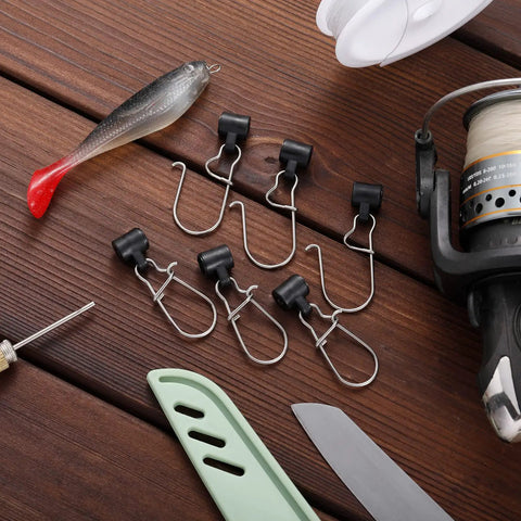 Set of opened duo lock clips from 50 Piece Sinker Slide Kit With Duo Lock Clips And Hooked Sinker Line Connectors For Freshwater And Saltwater Fishing Stainless Steel Snaps Durable Tackle Pro Grade on wooden background with fishing gear.