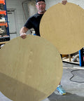 Person holding large wooden circles cut with Circle Cutter Router Jig For Precise Circle Cuts From Seven To Fifty Two And Three Quarters Inches