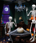 Indoor scene with Epic Life Size Halloween Skeleton With Movable Joints near a table, decorated for Dia De Los Muertos.