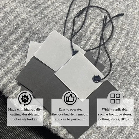 Premium Black Nylon Hang Tag Strings Featuring Slick Snap Lock Fasteners That Keep Your Apparel Pricing Secure Without Any Extra Hustle During Busy Retail Floors Or Weekend Maker Fests on a textured gray fabric.