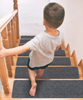 Child walking on 15 Piece Indoor Stair Treads For Wooden Steps Non Slip Carpet Runner Mats With Gray Stripe Pattern