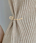 Top Shelf Loop Safety Pin Brooch Set Of Twenty Pieces Electroplated In Rich Golden Tone For Sweaters Coats And Jackets Featuring Reliable Non Slip Clasp To Keep Your Threads Secure on a ribbed sweater.