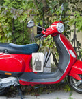 Waterproof Outdoor Outlet Box Cover For Charging Stations Featuring Hella Tough Pp Shield and Quick Install Setup to Keep Your Power Plugs Clean and Weather Ready Year Round hanging from a red scooter in a greenery backdrop.