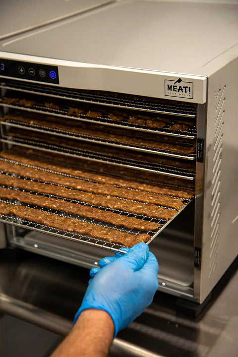 Heavy Duty Food Dehydrator With Digital Thermostat And Set It Forget It Timer six stainless steel trays with jerky being removed.