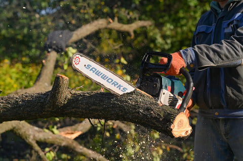 Person cutting a tree branch with a chainsaw, showing Three Eighths Inch Low Profile Fourteen Inch Chainsaw Chain In A Three Pack.