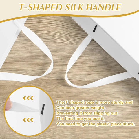 Close-up of T-shaped silk handle on a Three Pack Extra Large White Gift Bags With Handles 16 By 6 By 12 Inches Includes Six Tissue Papers For Birthday Wedding Holiday Shopping And Business Gift Wrap.