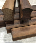 Close-up of polished solid walnut wood handles from 12 Pack Walnut Wood Drawer Pulls, 5.12 Inch Long, with visible grain.