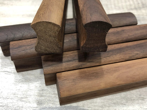 Close-up of polished solid walnut wood handles from 12 Pack Walnut Wood Drawer Pulls, 5.12 Inch Long, with visible grain.