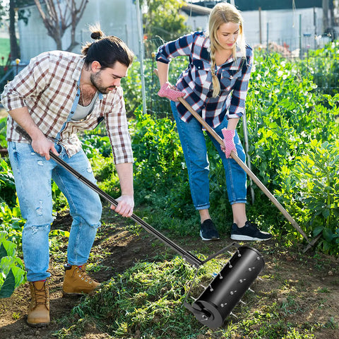 Two people using Beefy Rolling Lawn Aerator with fillable drum and 18 inch tine spikes for soil aeration in garden.
