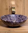 Elegant amethyst stone vessel sink with smooth glazed surface for modern bathroom vibes.