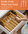 Person using an Expandable Bamboo Silverware Organizer For Drawers, Ultra Roomy 6 To 8 Slot Utensil Tray with natural finish in a kitchen drawer.