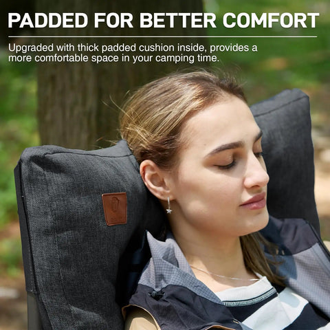 Woman relaxing on oversized padded folding camping chair for adults with high back support in outdoor setting