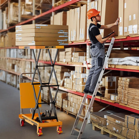 CAMMOO hydraulic lift table cart; yellow base with black scissor arms lifting boxes in a warehouse