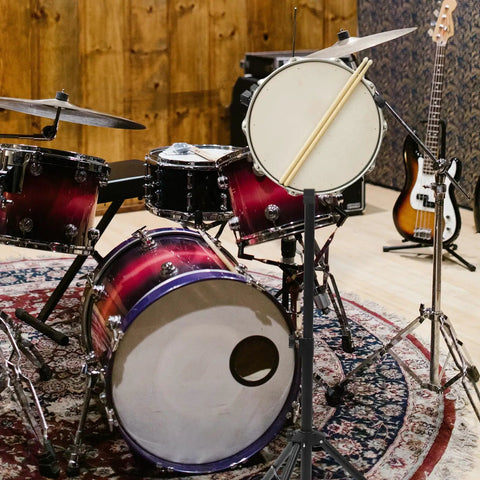 Badass Adjustable Snare Drum Rack And Practice Stand With Rock Solid Non Slip Base Plus Straight Up Portable Double Drumstick Shelf And Quick Hinge Height Adjustment For Pro Music Gear amidst a colorful drum set.