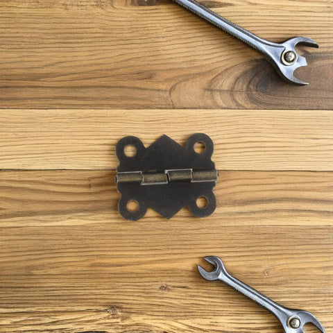 Antique Decorative Butterfly Hinges Set Of 24 For Jewelry Boxes And Cabinets on wooden surface with wrench