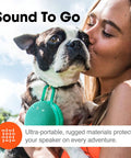 Woman holding dog with Clip 3 Fiesta Red Portable Bluetooth Speaker With Up To 10 Hours Of Playtime, Waterproof And Durable attached.