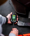 Person using 800 Milliampere SuperSmart Battery Charger And Maintainer in vehicle, showing automatic function with spark proof design.